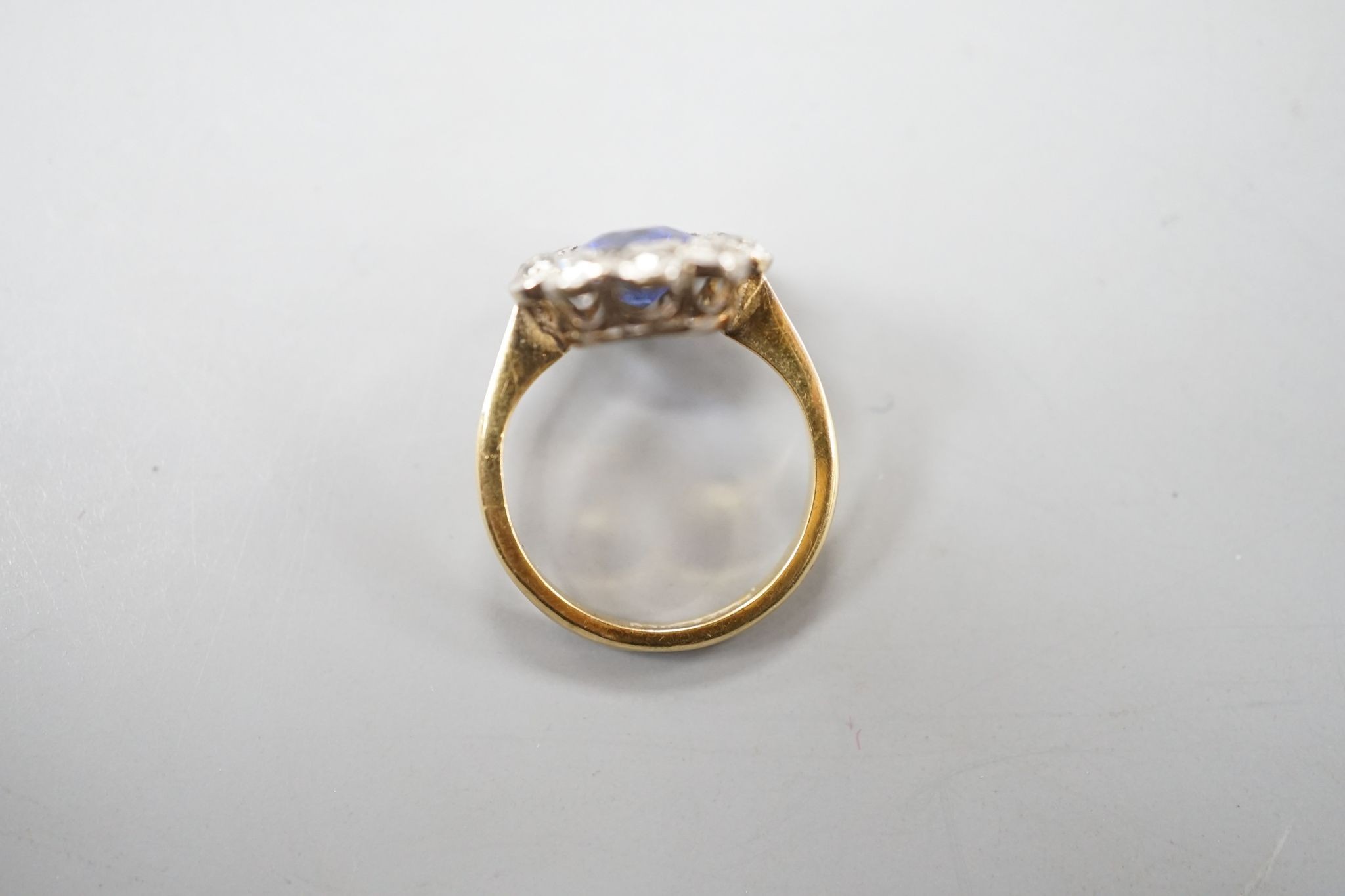 An 18ct gold and platinum, synthetic sapphire and diamond set oval cluster ring